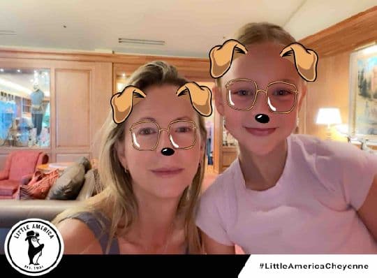 Two Little America Cheyenne guests posing with a dog photo filter