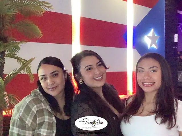 Three guests smiling for a branded photo at Made in Puerto Rico Orlando