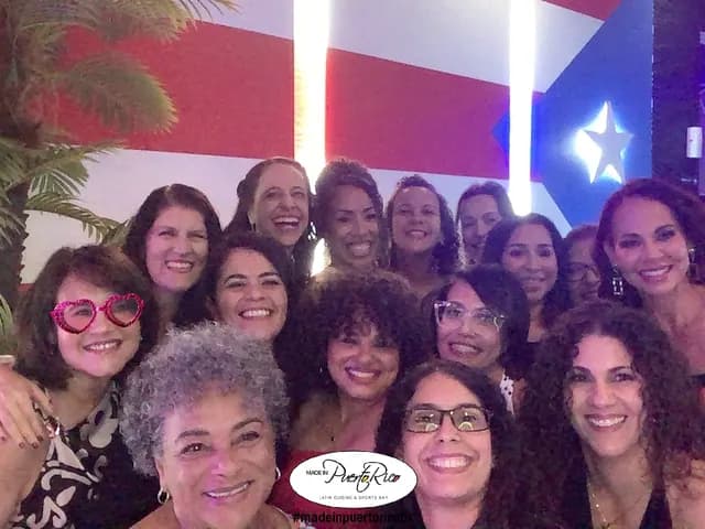 Guests posing together in front of the Puerto Rican flag at Made in Puerto Rico Orlando