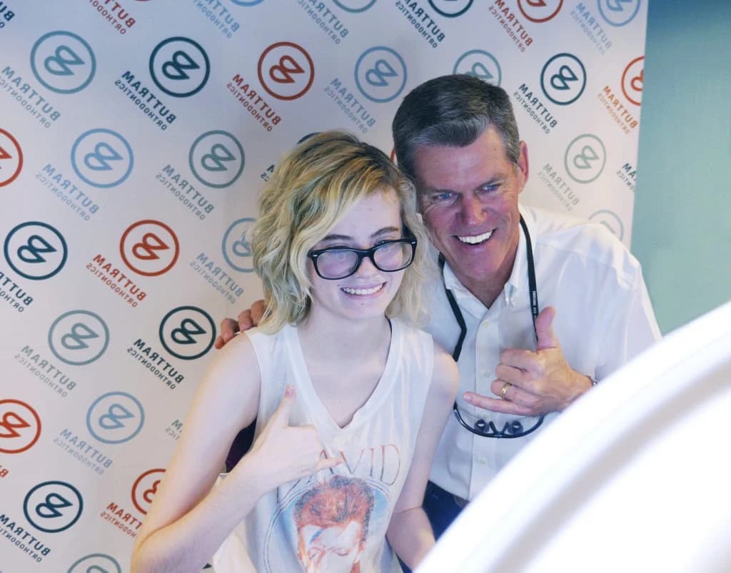 A patient posing with the doctor at Buttram Orthodontics