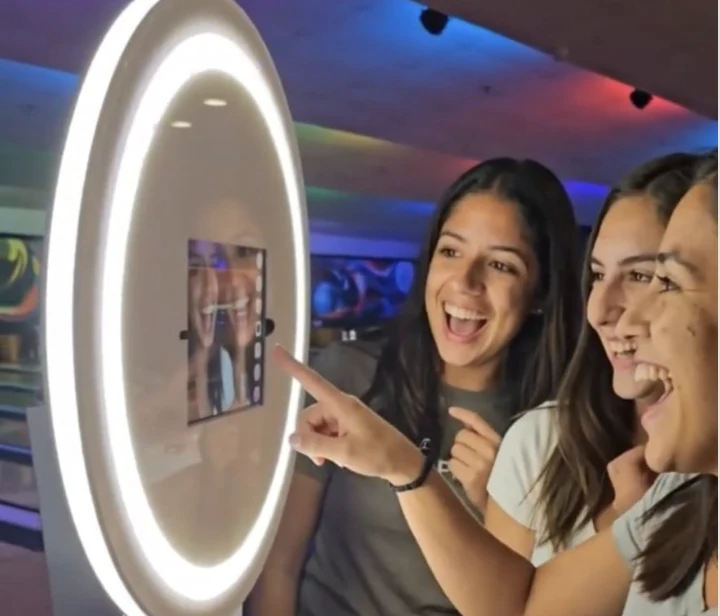 Guests reacting to their photo at a BuzzyBooth kiosk