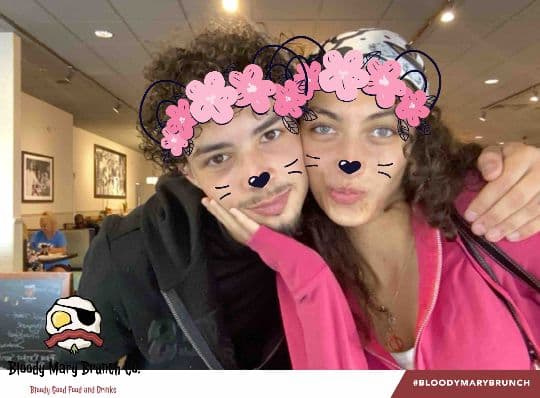 Two Bloody Mary Brunch Company guests posing with a flower and whiskers filter