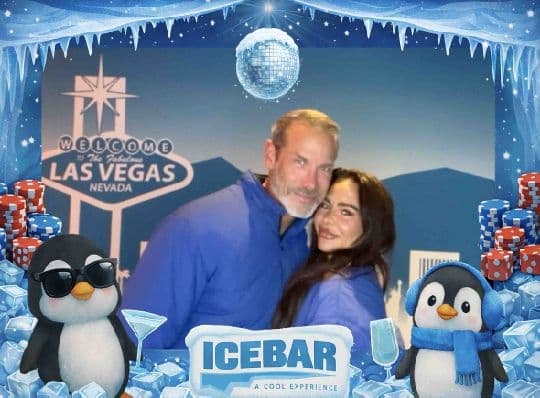 Two Ice Bar guests embracing in a branded photo