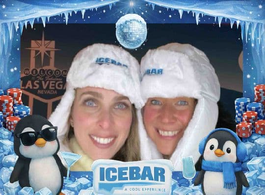 Two Ice Bar guests wearing white ice hats in a branded photo