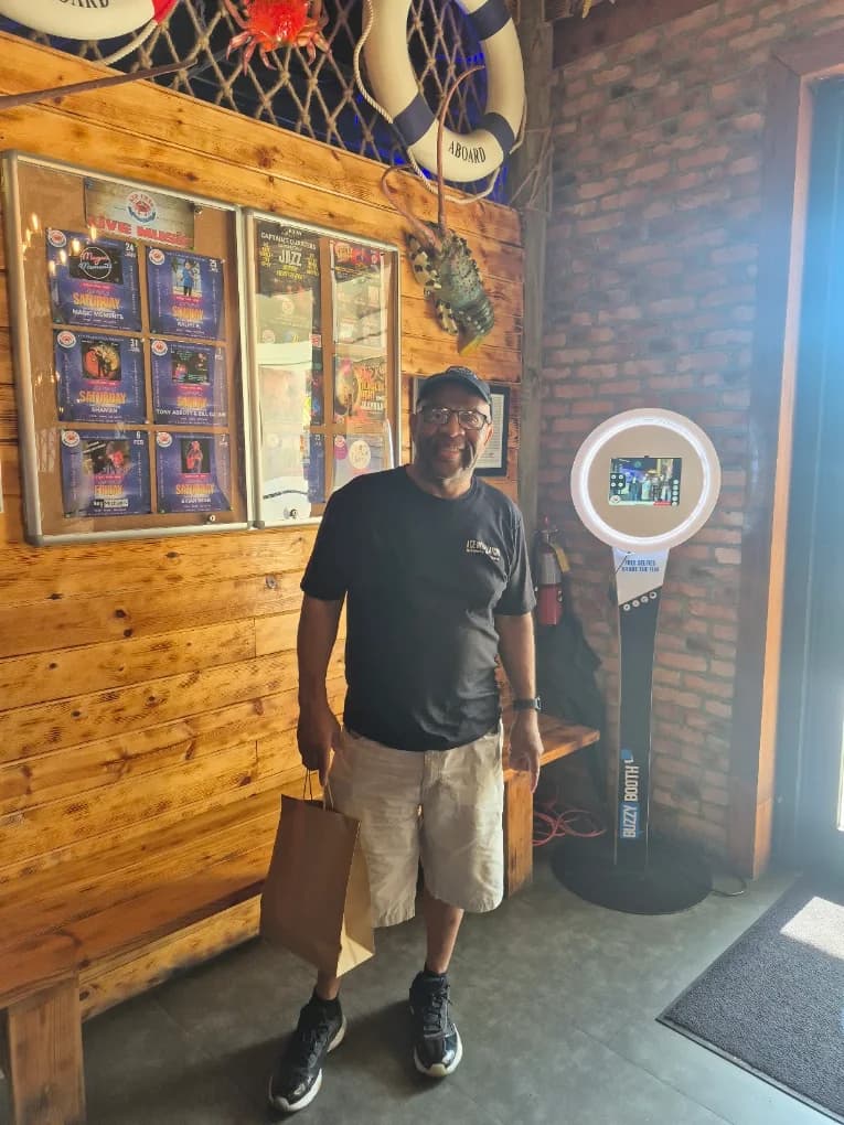 Person standing beside the BuzzyBooth installation at Red Crab Delray Beach