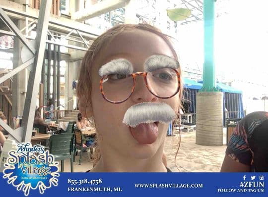 Splash Village guest posing with a playful moustache photo filter