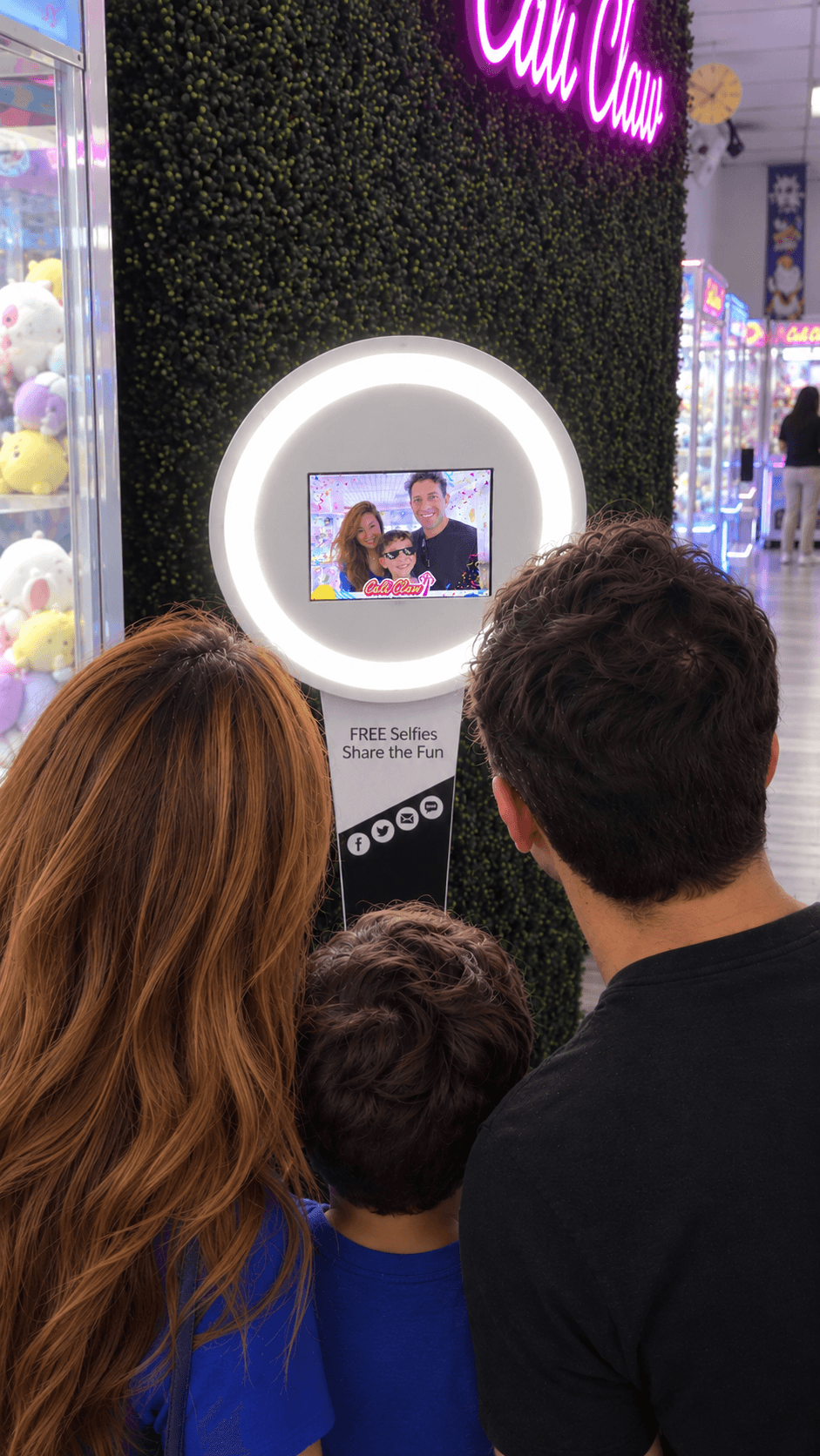 Family using a BuzzyBooth photo kiosk at Cali Claw Arcade